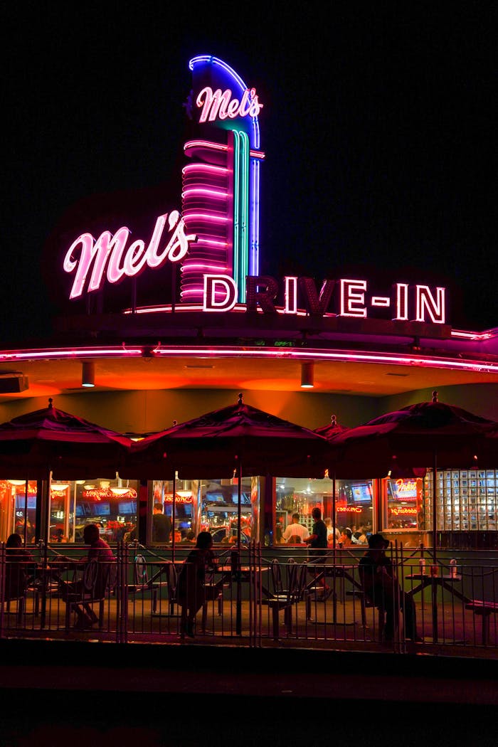 services-03 Bright neon lights of Mel's Drive-In capturing the essence of retro American nightlife.